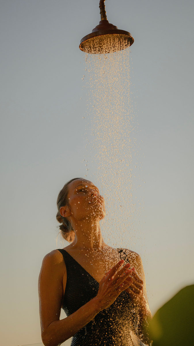 Guest under the outdoor shower at golden hour