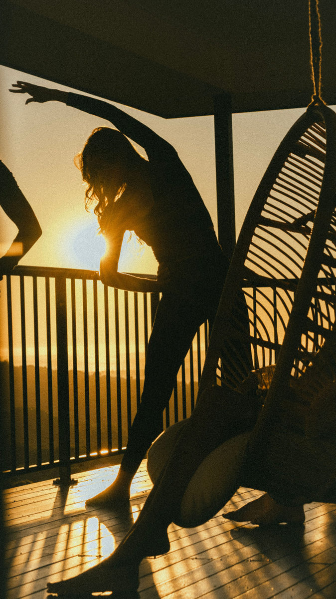 Silhouette of a guest stretching on the deck at sunset