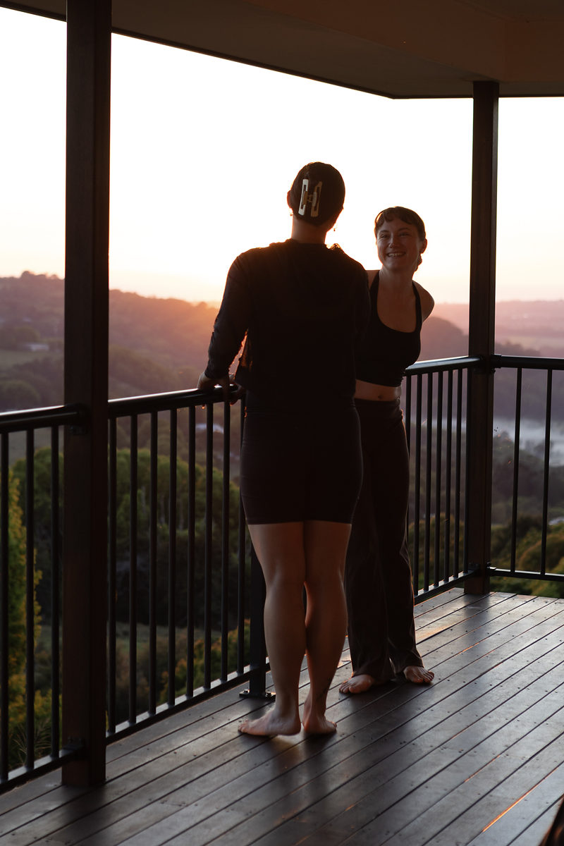 Two guests talking on the deck at sunset