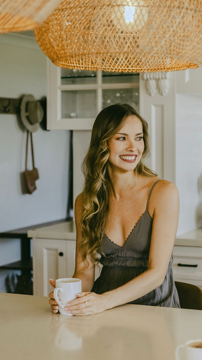 Smiling guest with a coffee at the kitchen bench