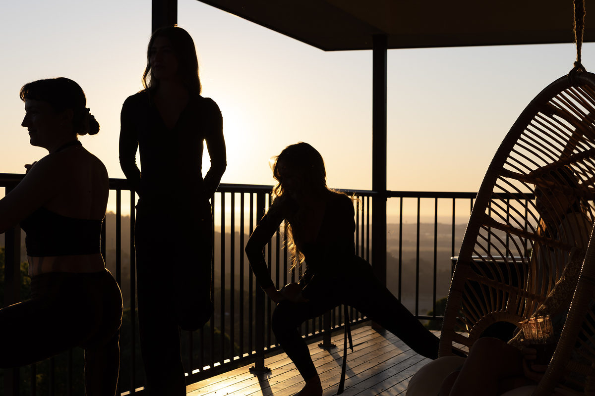 Silhouettes of guests on the deck against the sunset