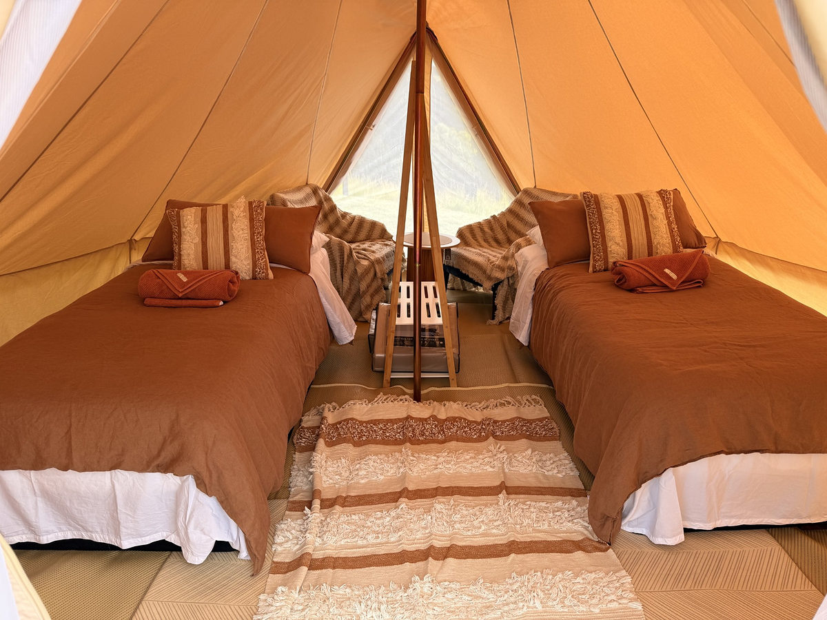 Inside a glamping tent with two made-up beds
