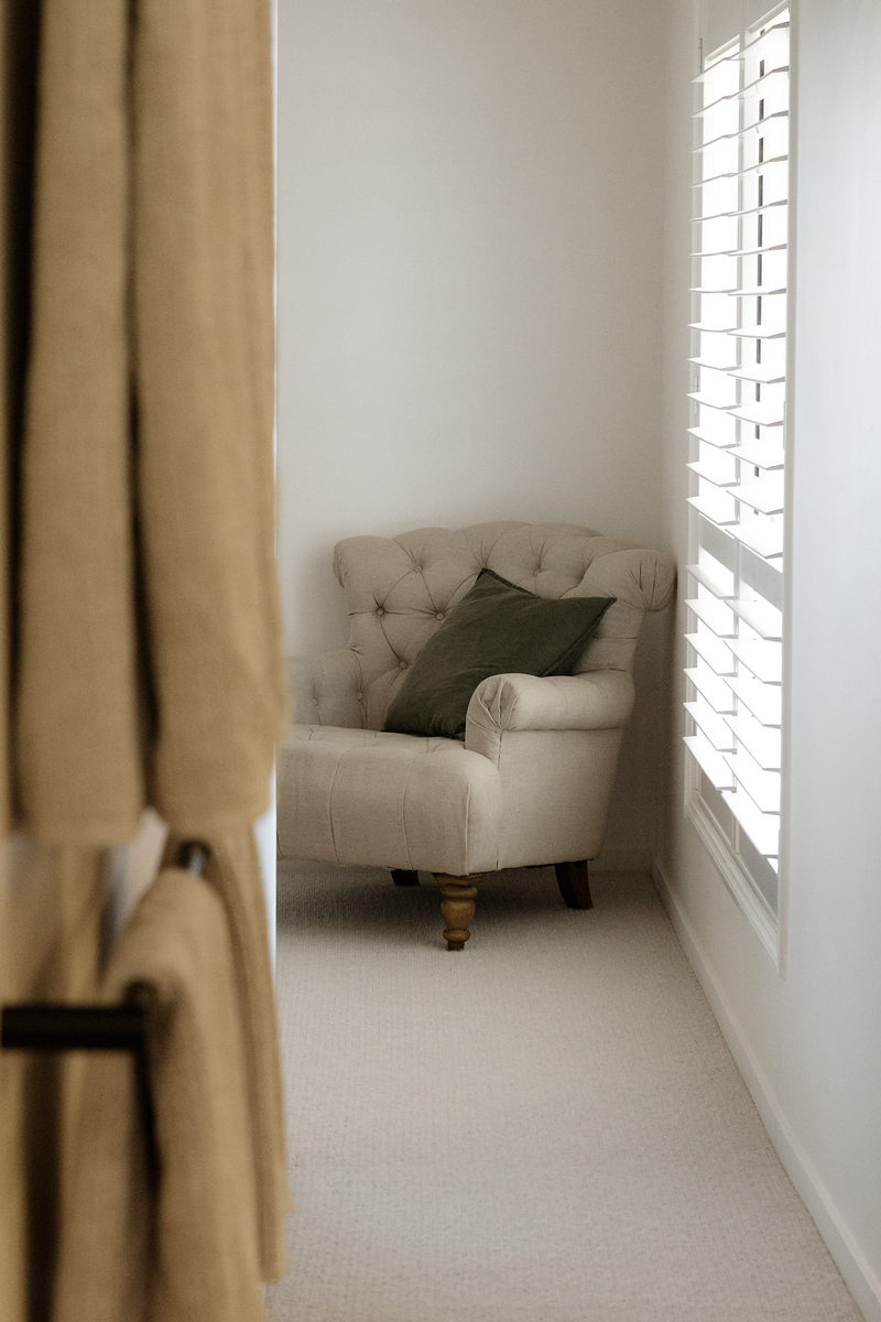 Bedroom corner with linen curtains and an armchair