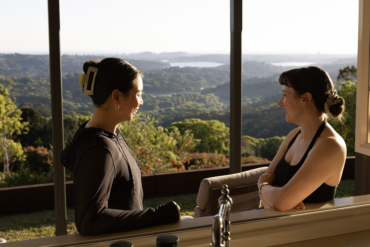 Two guests chatting by the window overlooking the hinterland