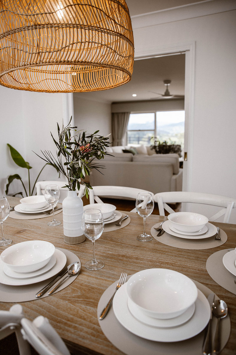 Dining table set beneath a woven pendant light