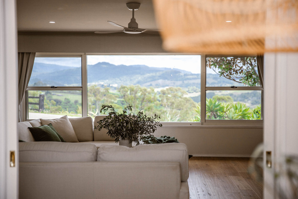 Living room with white lounges and hinterland views