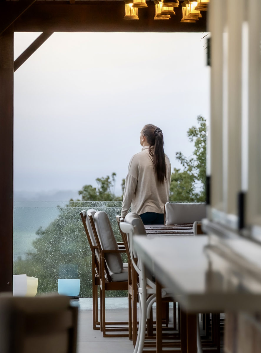 Guest looking out over misty hills from the kitchen