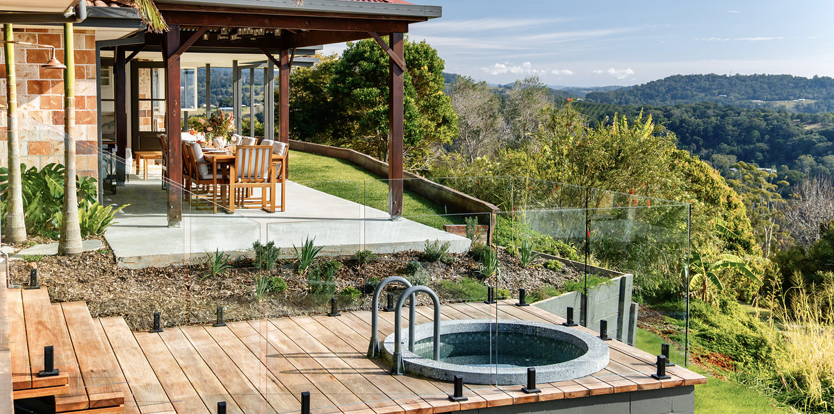 The covered alfresco deck, lawn and plunge with hinterland views