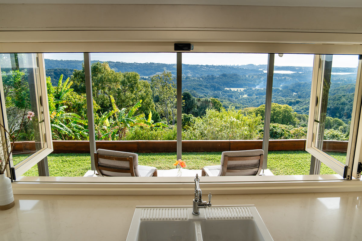 Kitchen window framing the green valley view