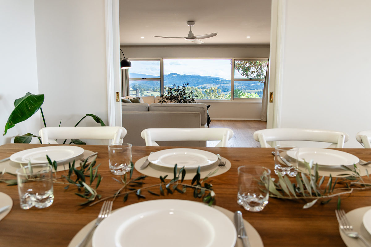 Dining table set for a shared meal with views beyond